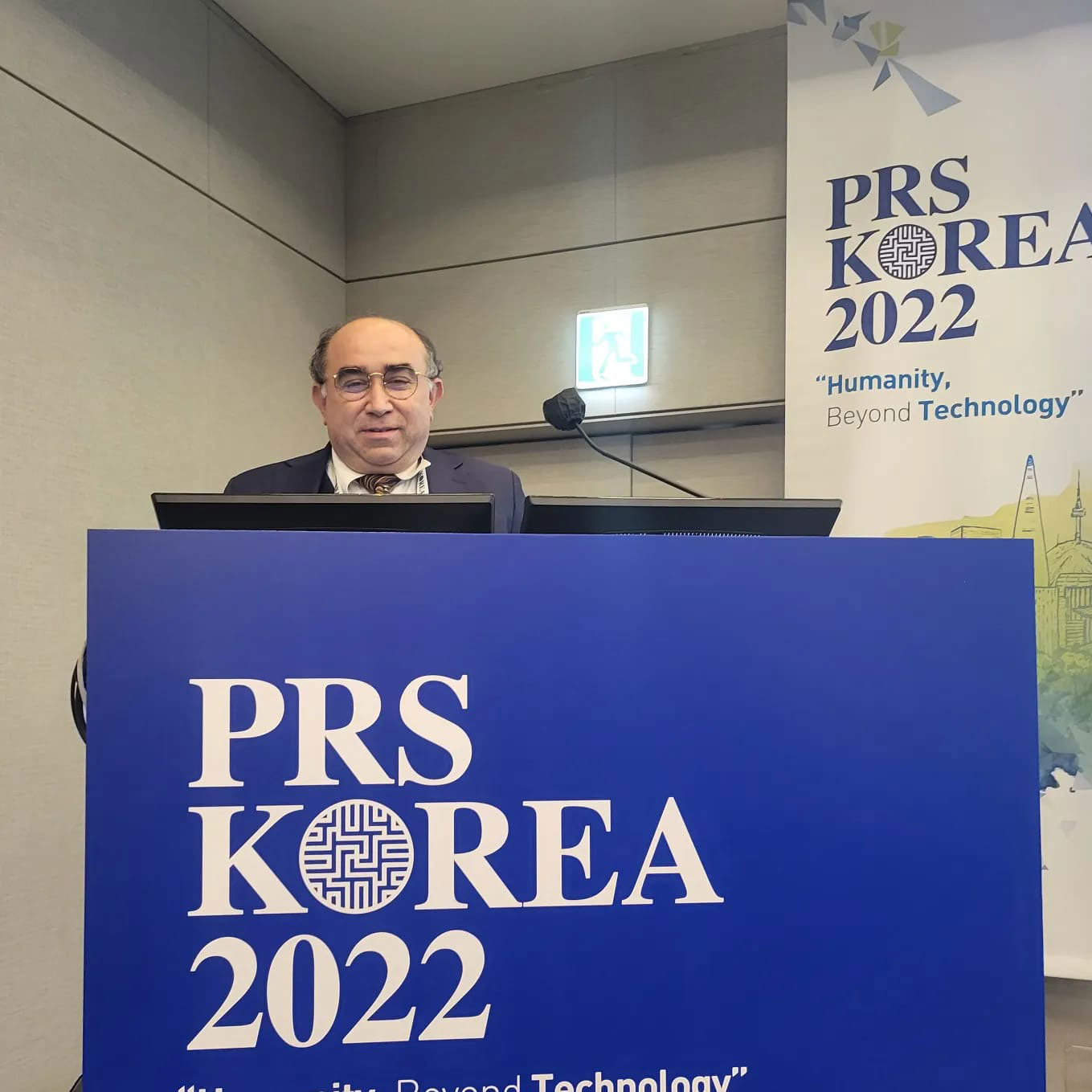 Copcu presenting behind a blue PRS Korea 2022 lectern